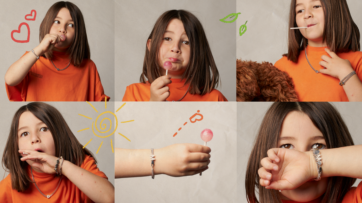 Joyful child enjoying lollipops while showcasing the alphabet kids bracelet in vibrant orange shirt.