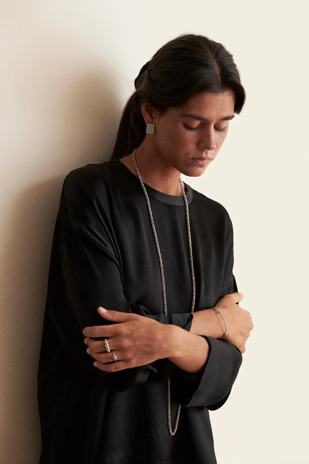 Best layered necklace styles showcased on a model wearing a stylish black outfit, highlighting elegance and modern aesthetics.