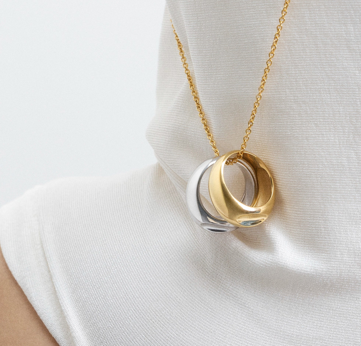 Ring size guide featuring elegant pendant with gold and silver rings.
