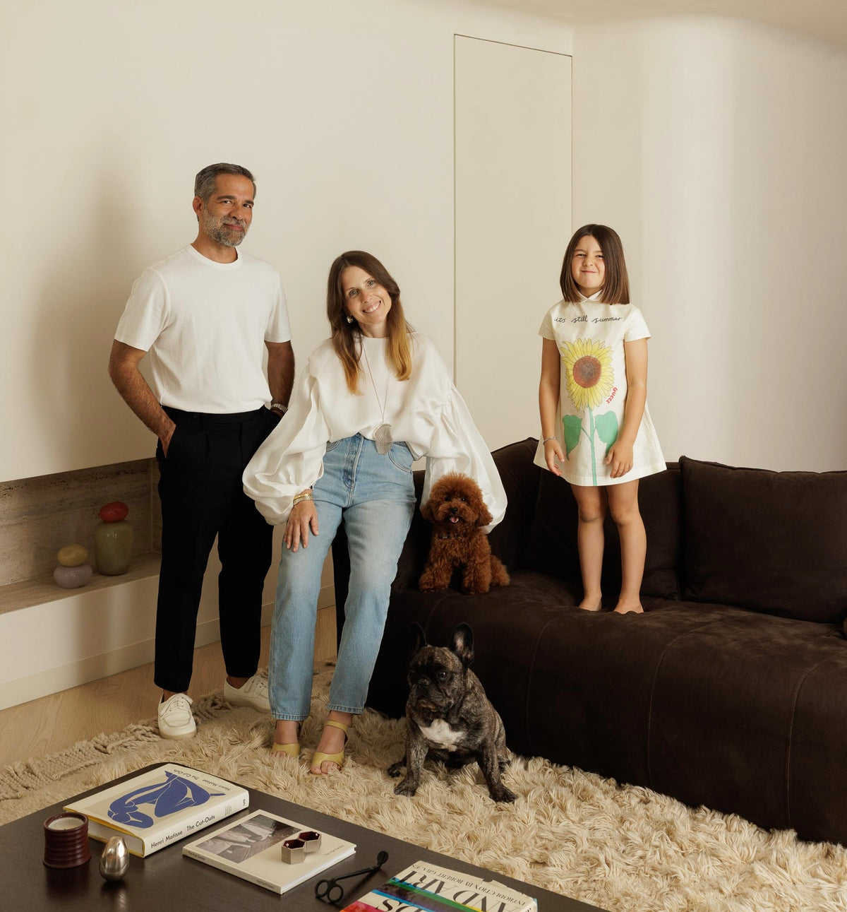 Famille de trois personnes avec deux chiens dans un salon