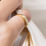 Gold ring on a finger with a soft background