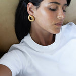 model wearing claudine earrings in gold