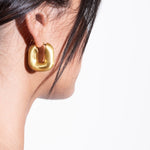 model wearing magda earrings in gold