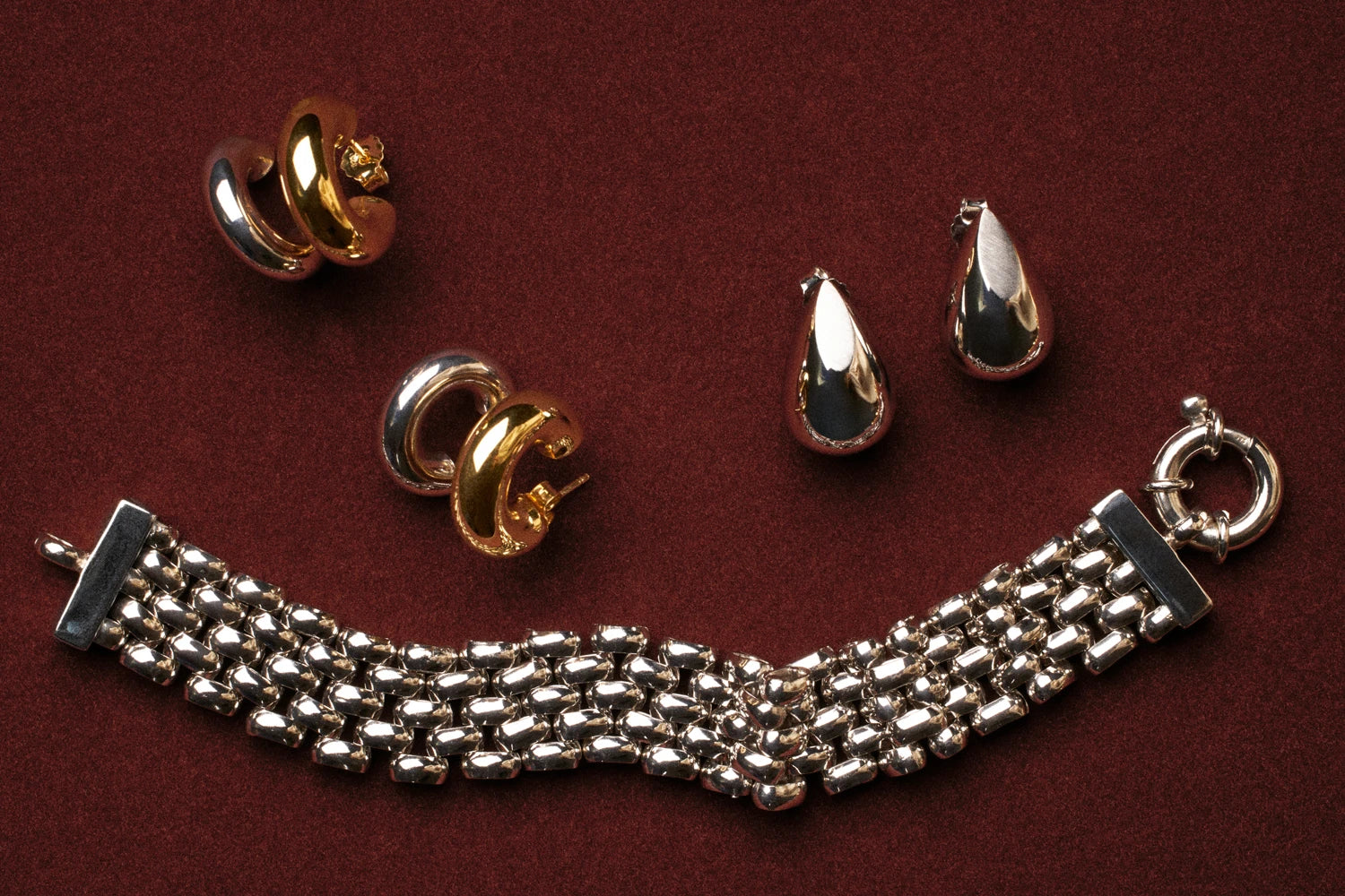 Gold and silver jewelry on a red background